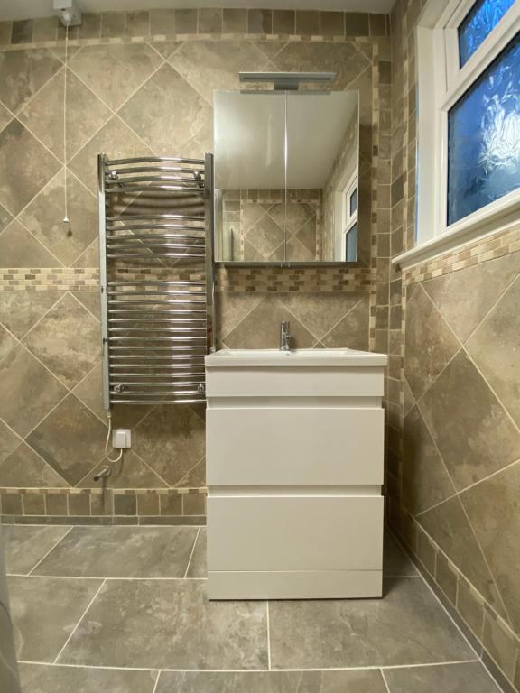 uma casa de banho com um lavatório branco e um espelho. em Eagle House Holiday Let em Bude