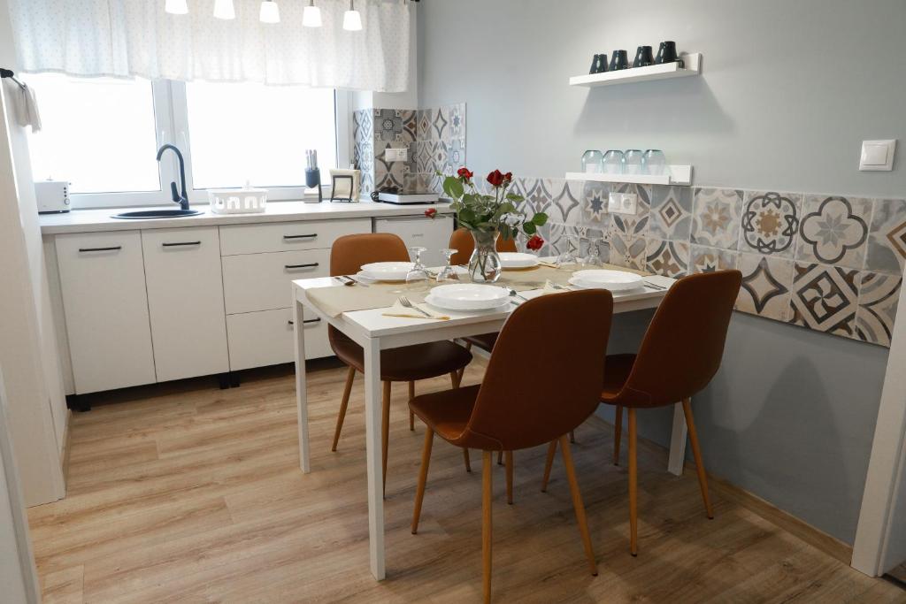 uma cozinha com mesa e cadeiras num quarto em Apartman 3 em Komárom