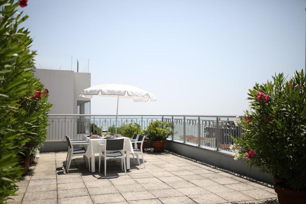 a table and chairs with an umbrella on a balcony at Residence Mariavittoria in Lido di Jesolo