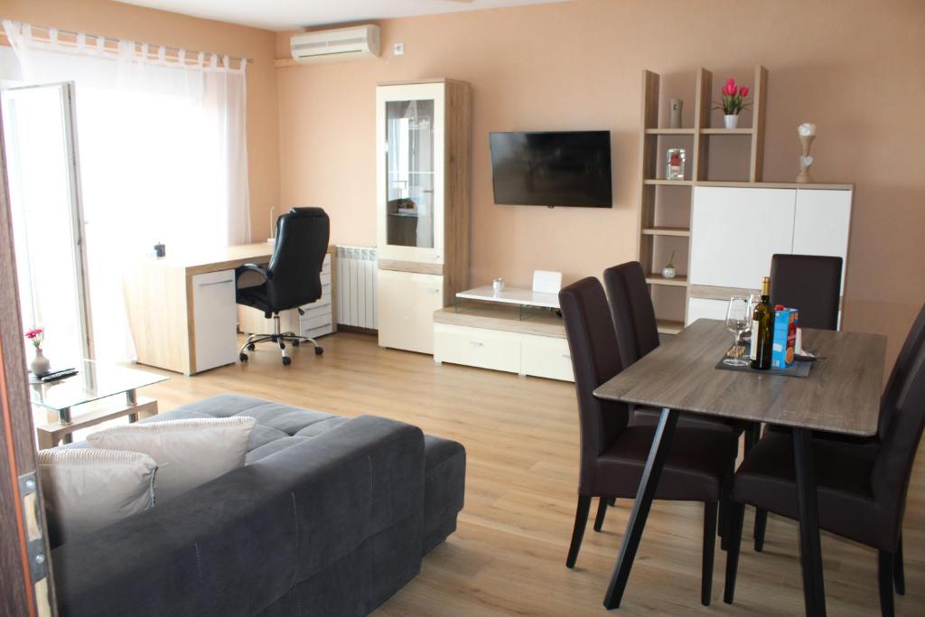 ein Wohnzimmer mit einem Sofa und einem Tisch in der Unterkunft Apartman Lovro in Rijeka