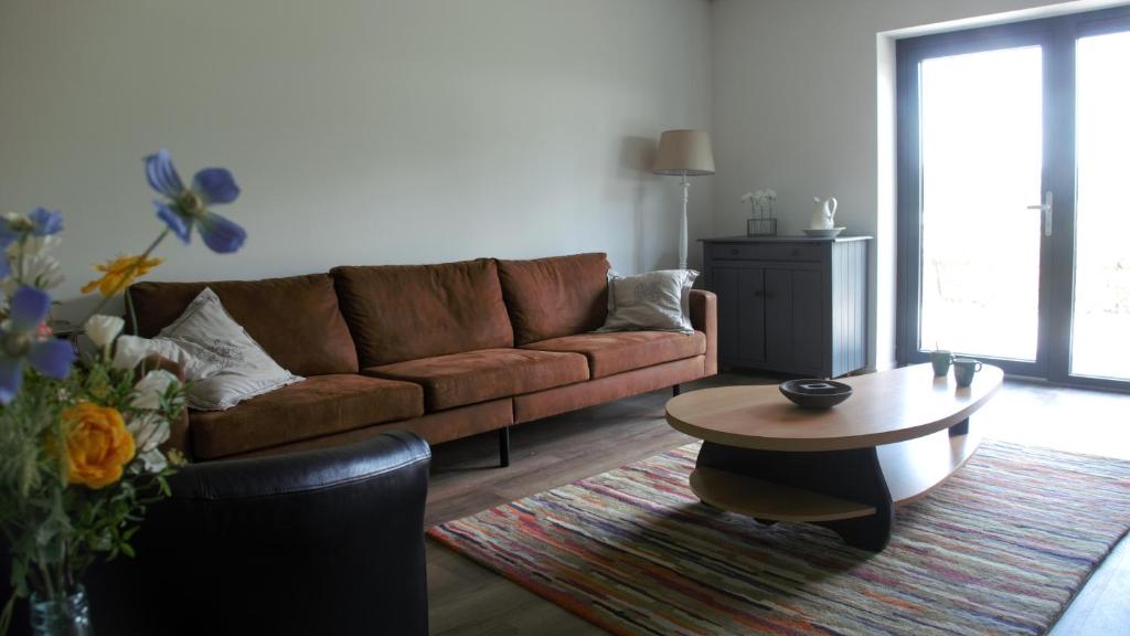 a living room with a brown couch and a coffee table at Buiten in Bladel in Bladel