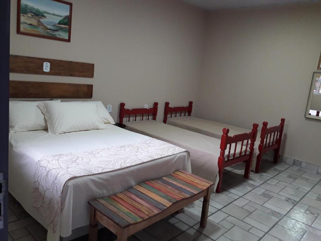 sypialnia z 2 łóżkami i ławką w obiekcie Pousada DuBaldo w mieście Holambra