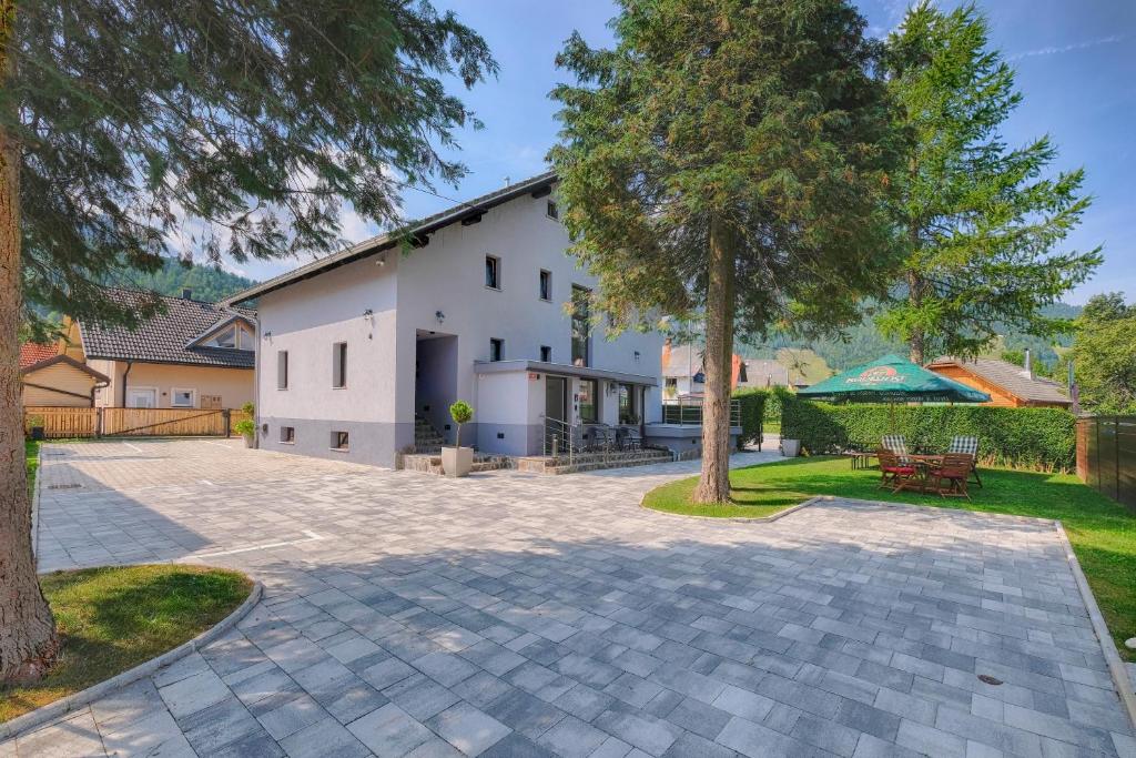 Casa blanca con un árbol y un patio en Pri Marusi en Kranjska Gora