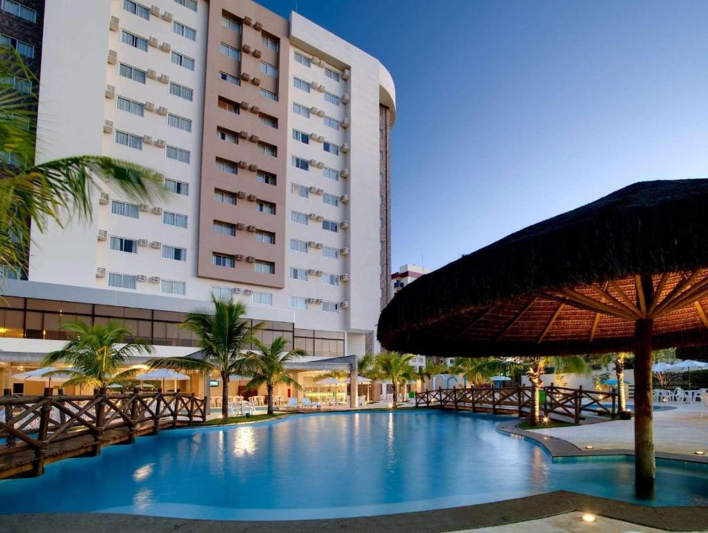 a hotel with a swimming pool and a large building at LE JARDIN Suites in Caldas Novas