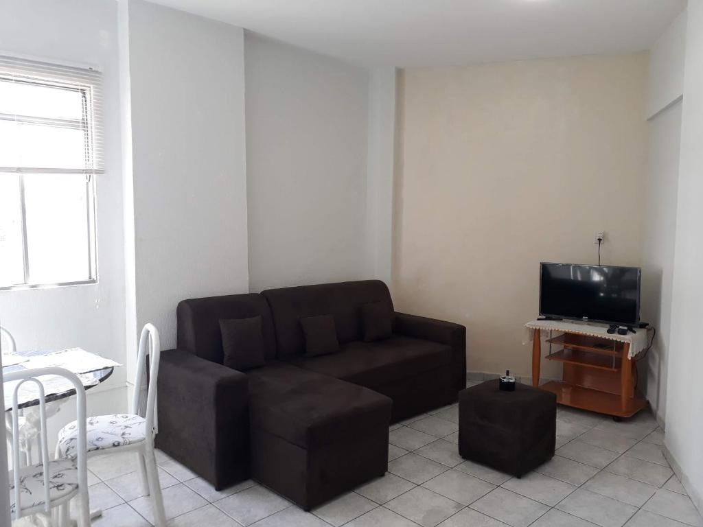 a living room with a brown couch and a tv at no centro de Cuiabá aptº mobiliado in Cuiabá