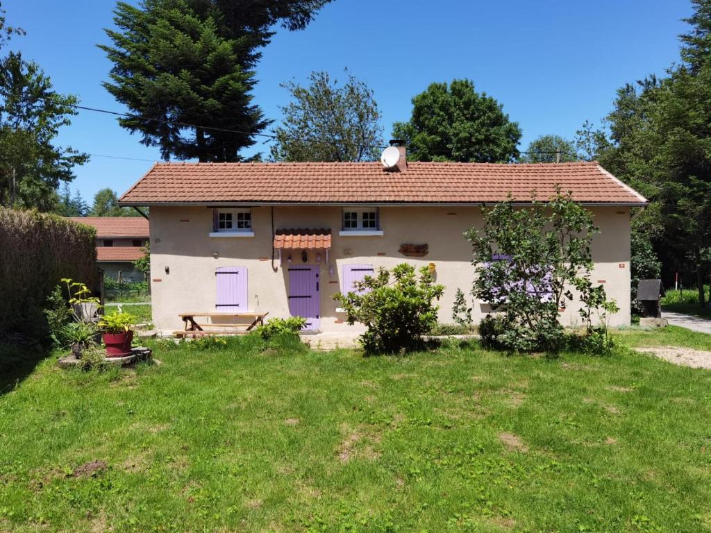 a house with purple doors in a yard at A la croisée des chemins in Saint-Nicolas-des-Biefs