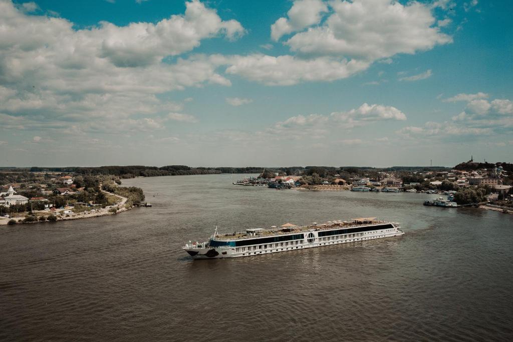 eine Fähre auf einem Fluss mit einer Stadt in der Unterkunft Diana Sunshine Apartment in Tulcea