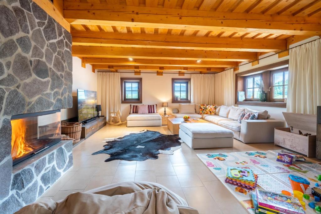 a living room with a fireplace and a stone wall at Chalet Zuberec, 5 apartments, jacuzzi, sauna, mountains in Zuberec