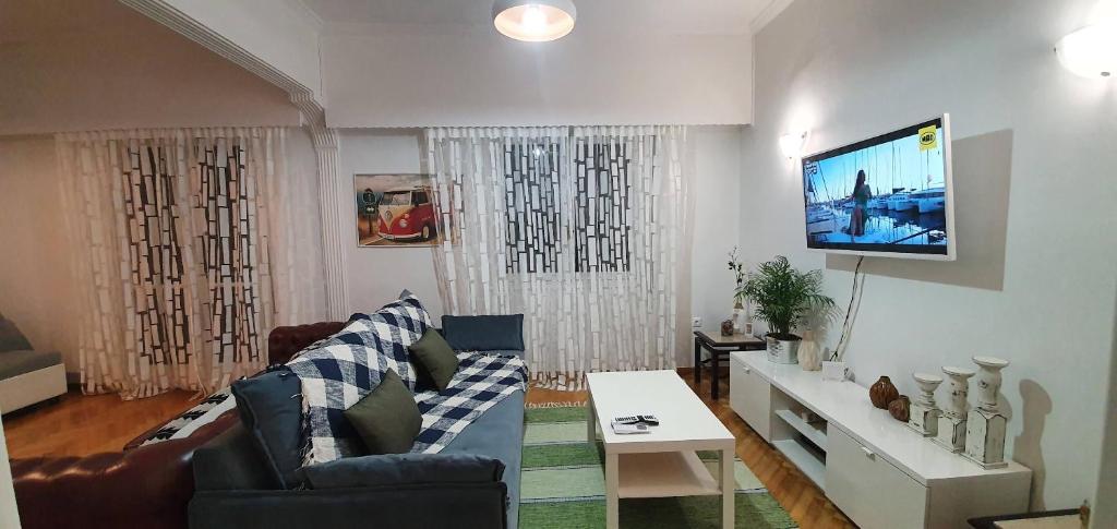 a living room with a couch and a flat screen tv at Beautiful Renovated Flat in Athens (The Dem Flat) in Athens