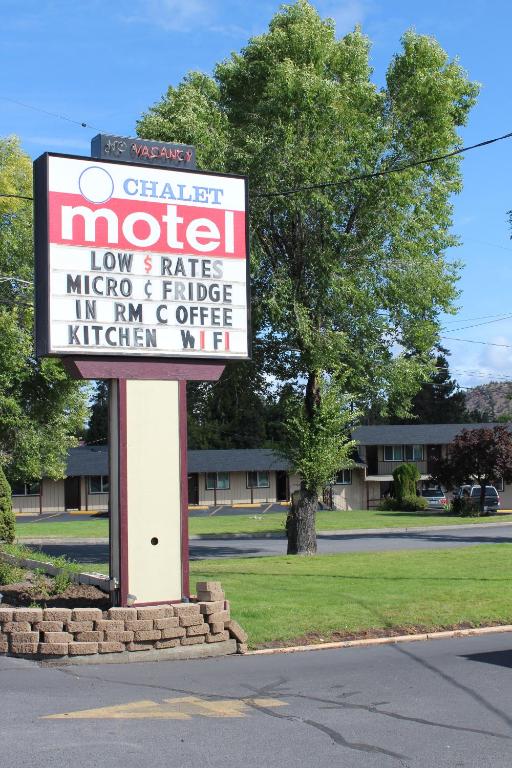 una señal para un motel al lado de una calle en Chalet Motel, en Bend