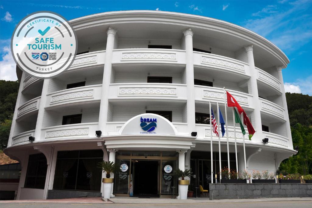 a large white building with flags in front of it at Zir Dream Thermal & Spa Hotel in Termal