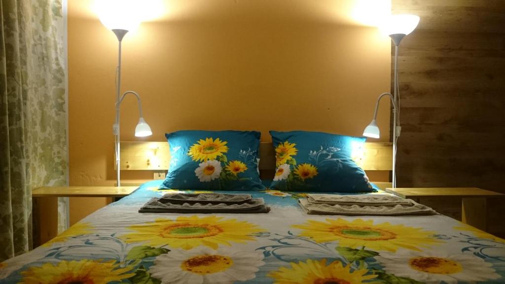 a bed with yellow and white flowers on it at Willow Apartments in Limbaži