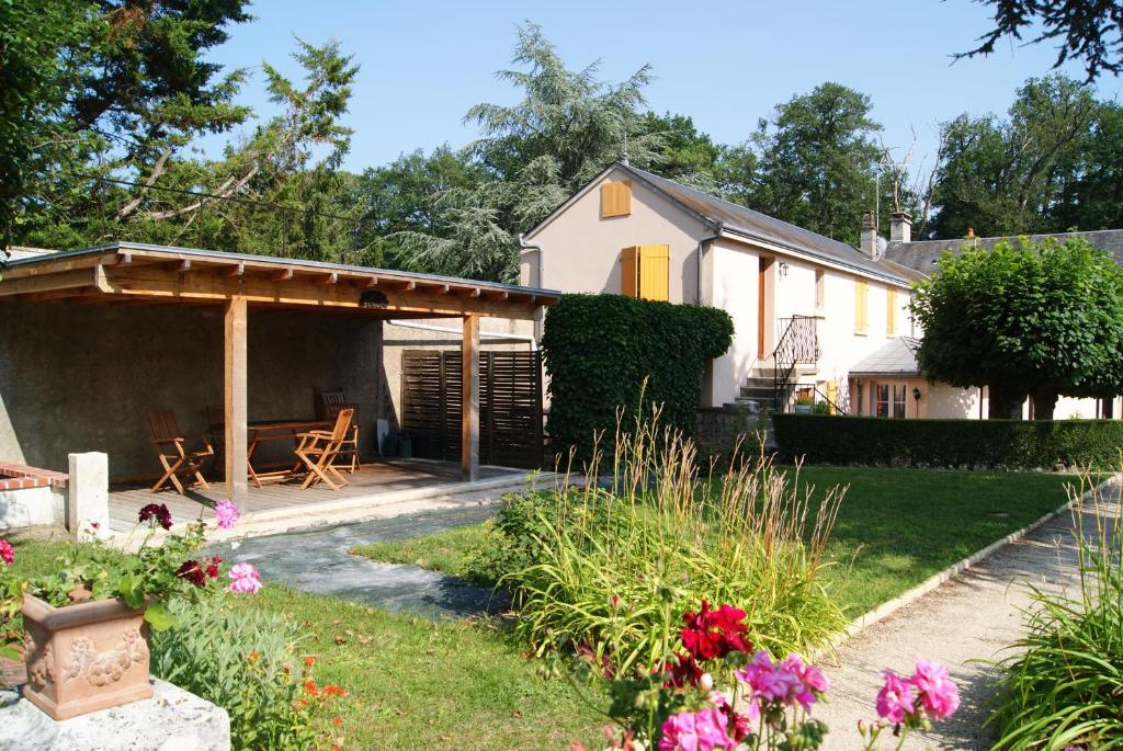 una casa con patio y flores en el patio en La Valinière, en Seur