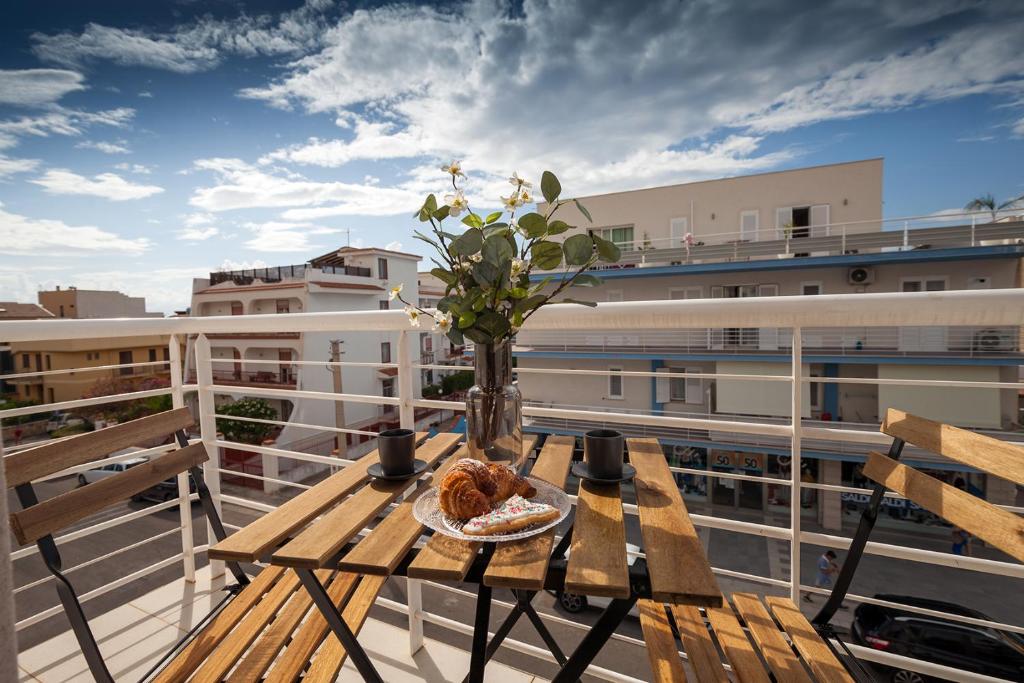 a table with a vase of flowers on a balcony at Nerissa suites&rooms in Terrasini