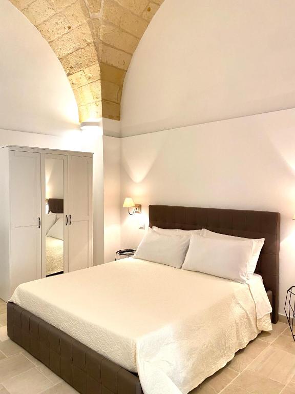 Un dormitorio con una cama grande con sábanas blancas. en Dadaumpa suite, en Lecce