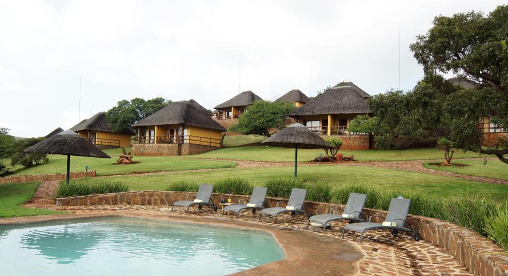 un complejo con piscina, sillas y algunas casas en Hannah Game Lodge, en Ohrigstad