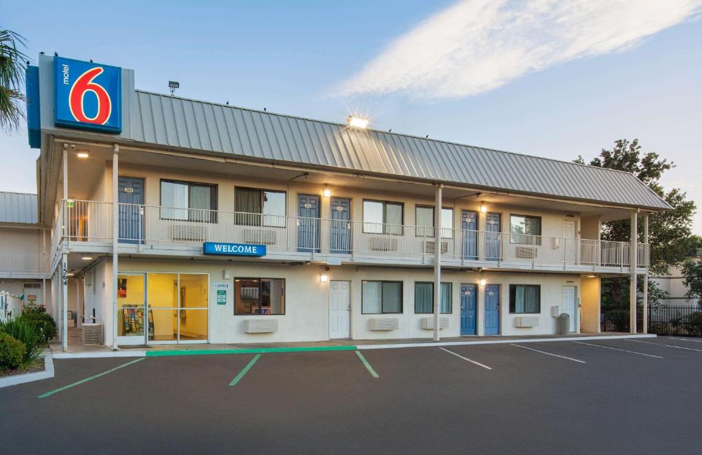 a hotel with a parking lot in front of it at Motel 6-Woodland, CA Sacramento Airport in Woodland