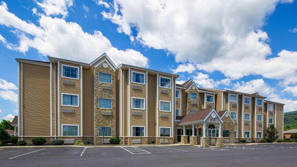an exterior view of a building with a parking lot at SureStay Plus Hotel by Best Western Keyser in Keyser