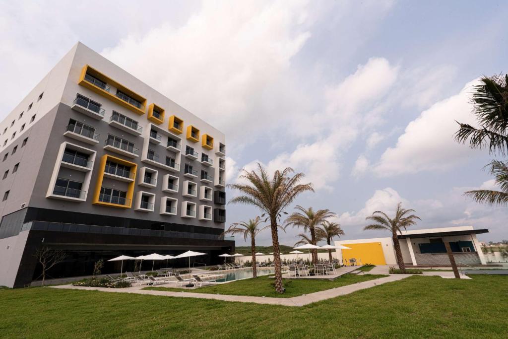 ein Hotel mit Palmen vor einem Gebäude in der Unterkunft Best Western Plus Riviera Veracruz in Veracruz