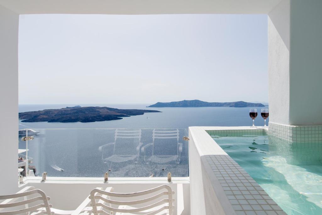 a swimming pool with a view of the water at Villa Renos Hotel in Fira