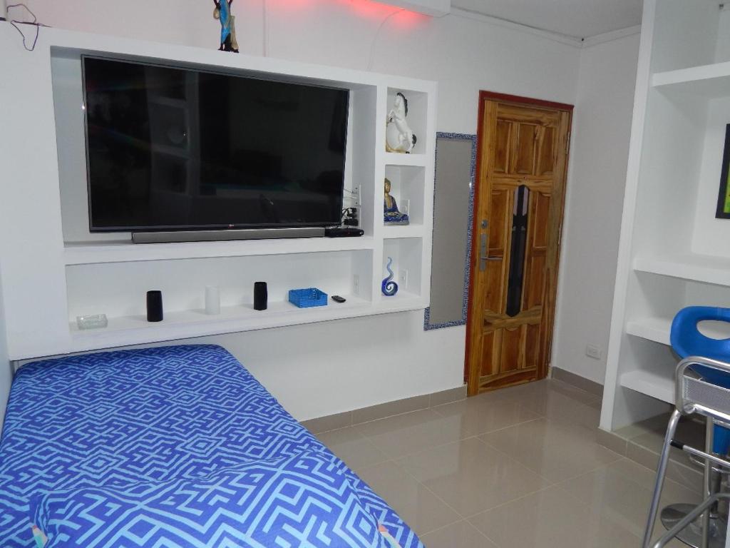 a bedroom with a flat screen tv and a bed at Delfin 207 in Cartagena de Indias