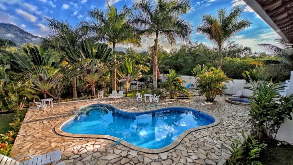 - une piscine dans une cour avec des palmiers dans l'établissement Jabaquara Beach Resort, à Parati