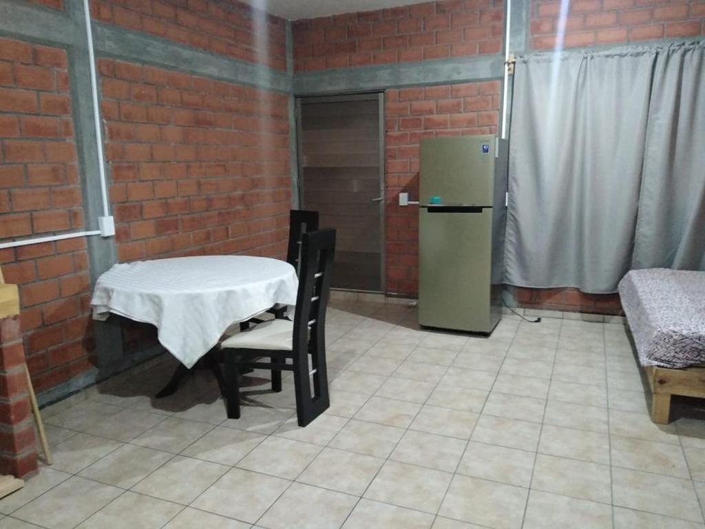 a brick room with a table and a refrigerator at Departamento La iguana in Valente Díaz y La Loma