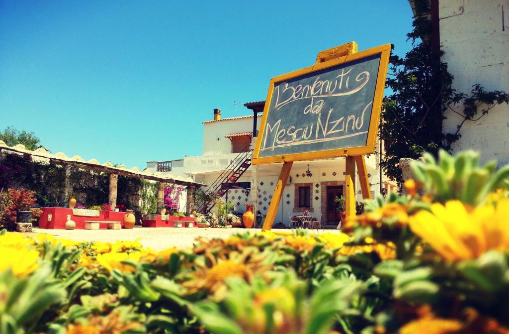 a sign for a restaurant of a restaurant with flowers at Da Mesciu Nzinu in Sannicola