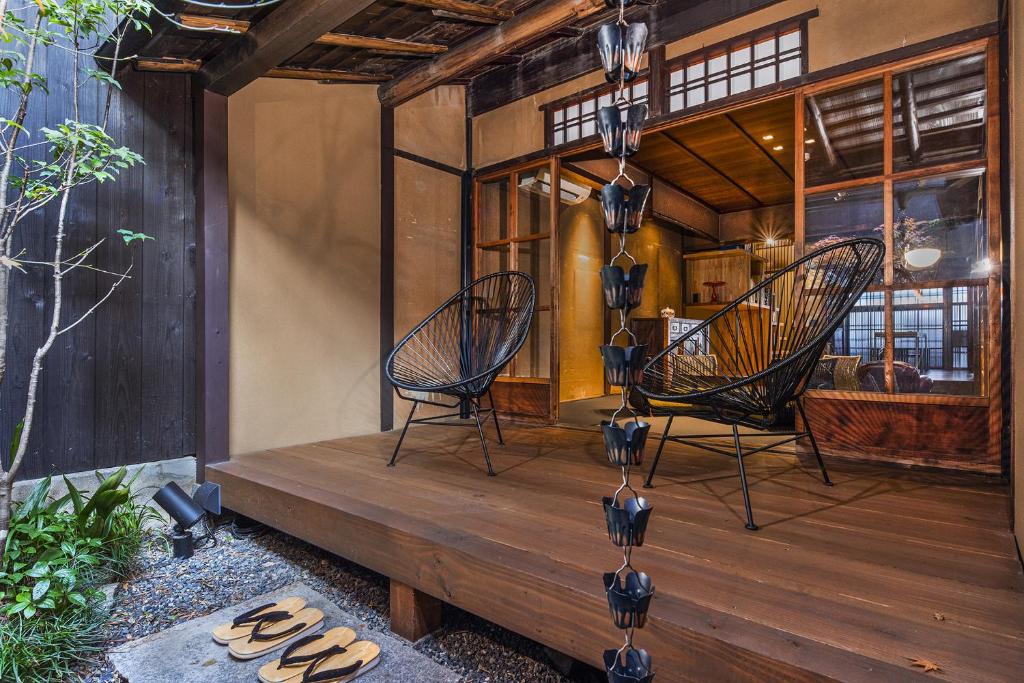 two chairs sitting on a wooden deck in a house at Kishoan in Kyoto
