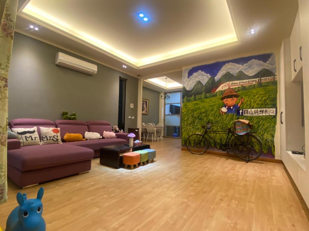 關山的住宿－ 觀關嚮戶民宿，客厅配有紫色沙发和绘画