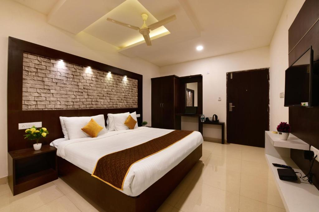a bedroom with a large bed with a brick wall at Hotel BV Colours Bommanahalli in Bangalore