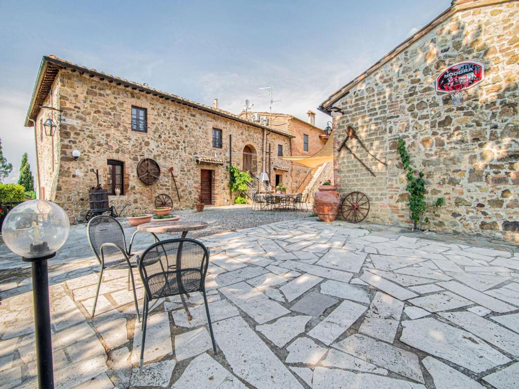 einen steinernen Innenhof mit Stühlen vor einem Gebäude in der Unterkunft Belvilla by OYO Villa Giovanna in Montalcino