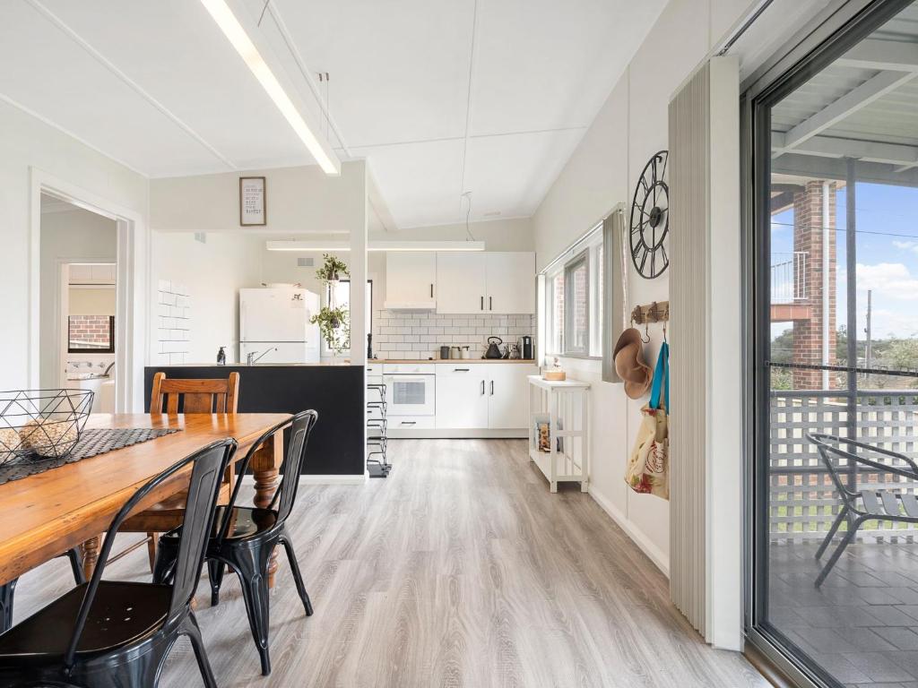 a kitchen and dining room with a table and chairs at The Shack by Experience Jervis Bay in Vincentia