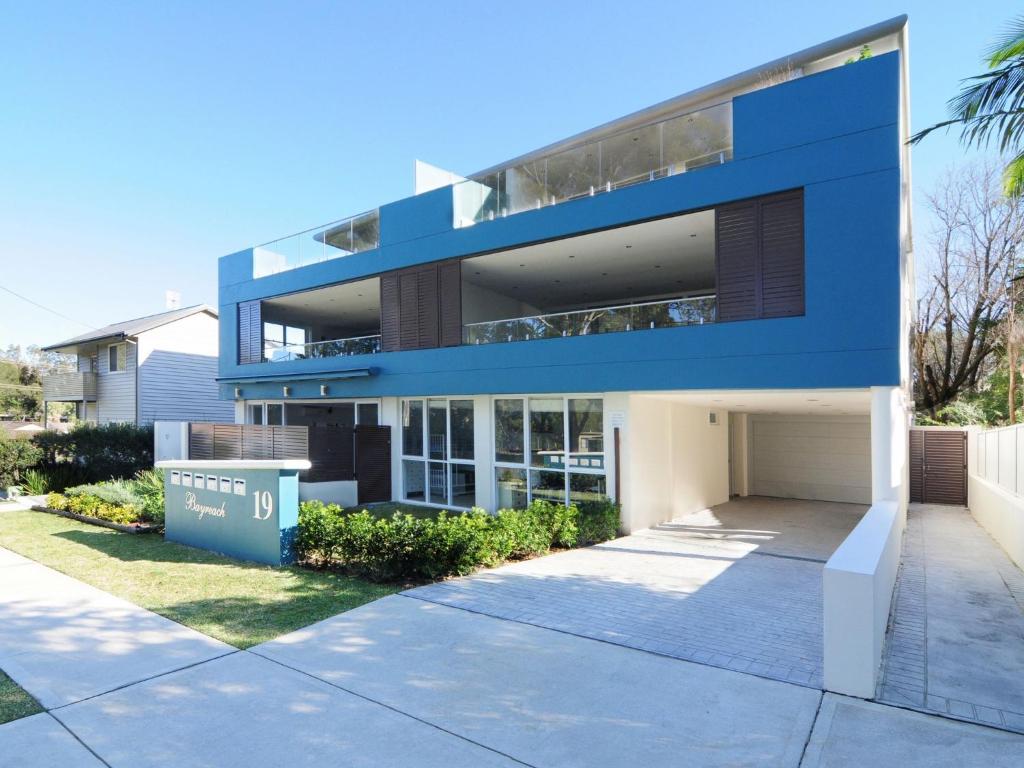 a large blue building with a driveway at Bombara by Experience Jervis Bay in Huskisson
