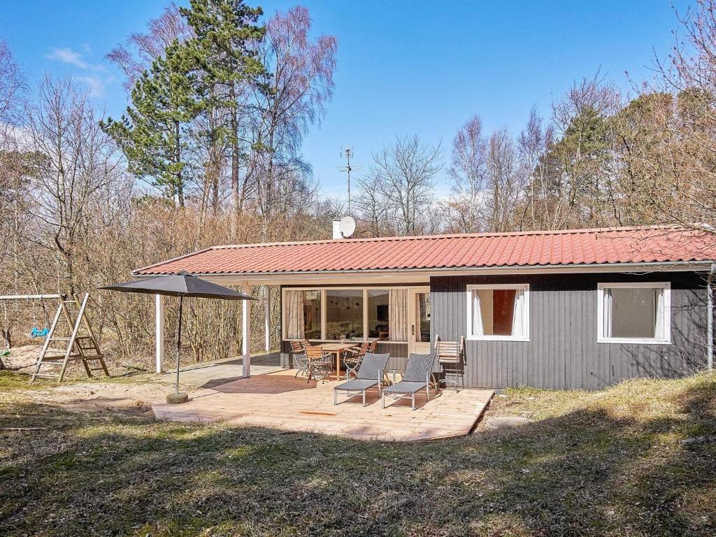 a small house with a patio with a table and chairs at 4 person holiday home in Aakirkeby in Vester Sømarken