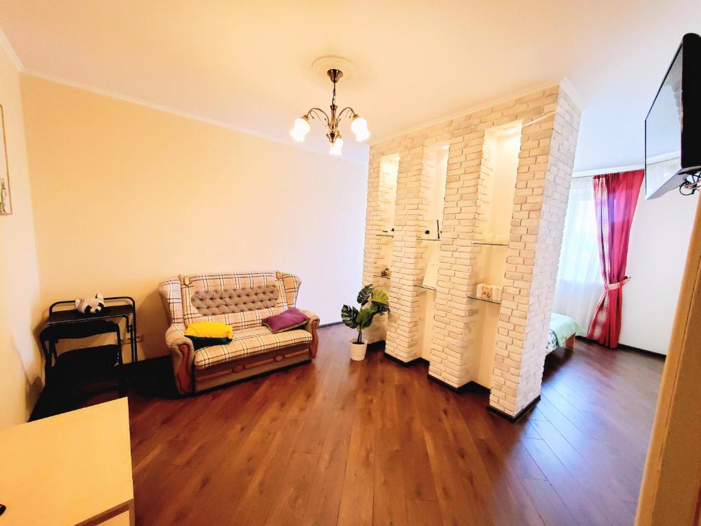 salon z kanapą i drewnianą podłogą w obiekcie Golosievo residence 60m2 w Kijowie