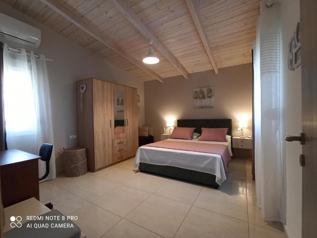 1 dormitorio con 1 cama con almohadas rosas en 4 Seasons House, en Amoudara Herakliou