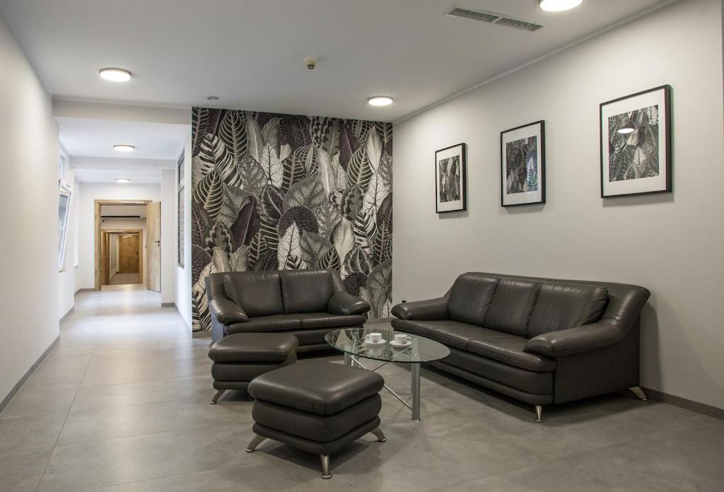 a waiting room with two leather couches and a table at Hotel Alexander in Krakow
