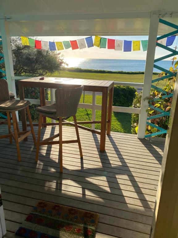 a table and chairs on a porch with a view of the ocean at 35 Flinders Ave in Dunwich