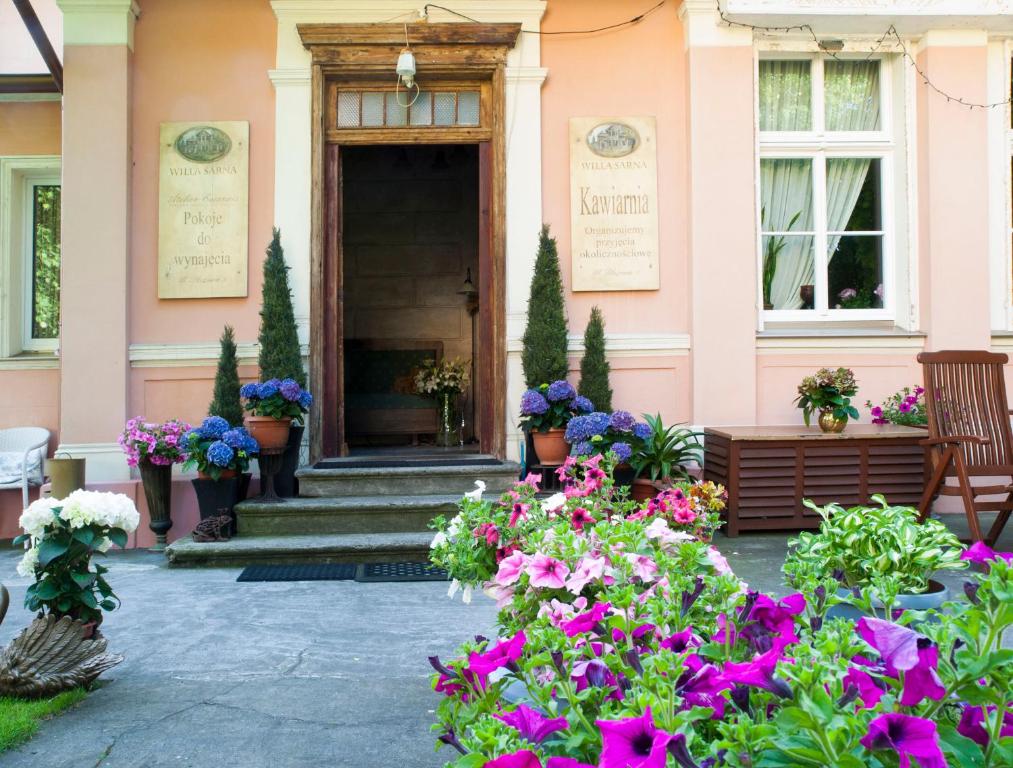 a pink house with flowers in front of it at Willa Sarna in Międzyzdroje