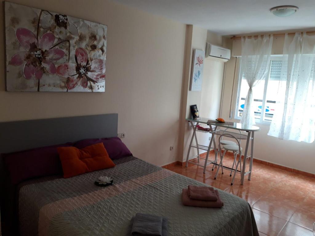 Schlafzimmer mit einem Bett, einem Tisch und einem Fenster in der Unterkunft Almudena Estudio in Torrevieja