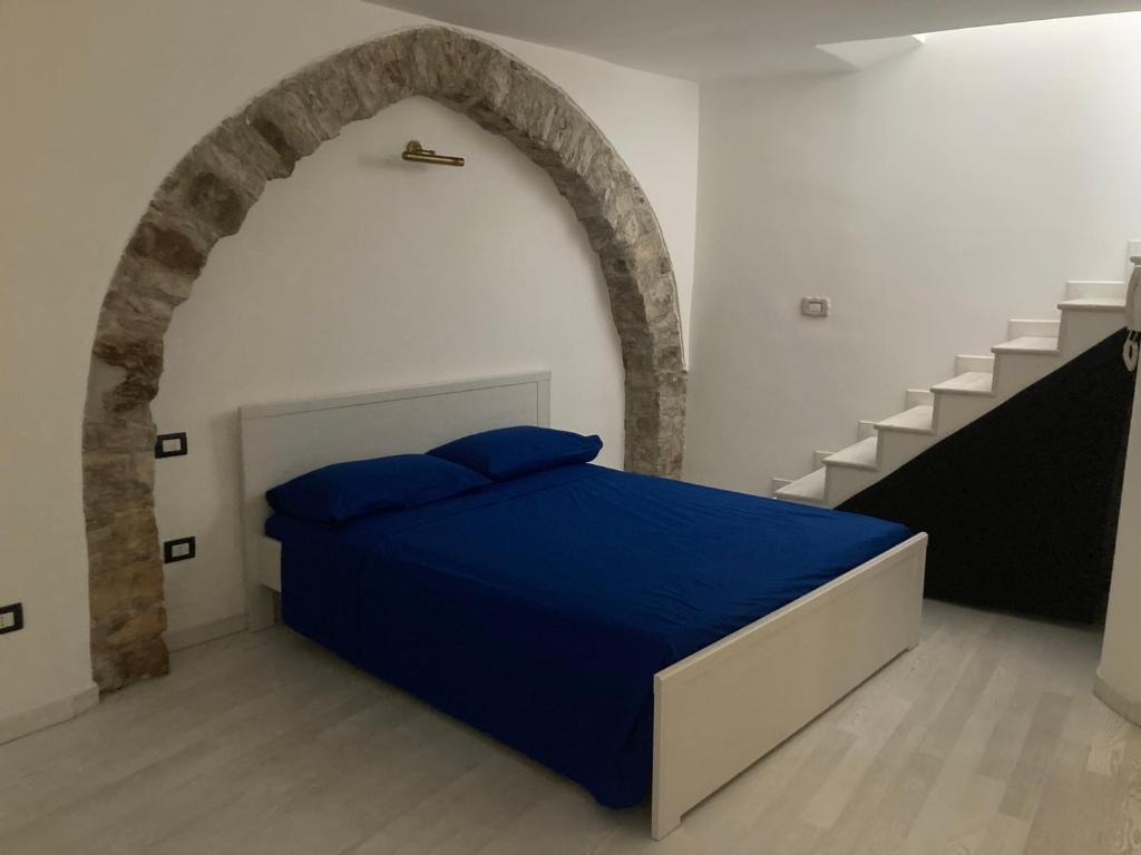 a bedroom with a blue bed in a room with stairs at La Casa Di Noah in Venosa