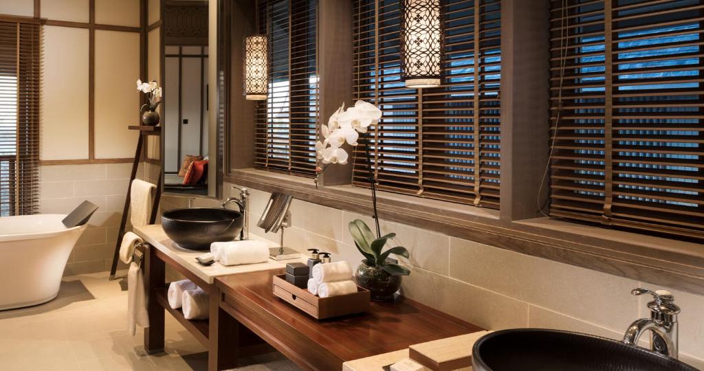 a bathroom with a sink and a counter with towels at Anantara Desaru Coast Resort & Villas in Desaru