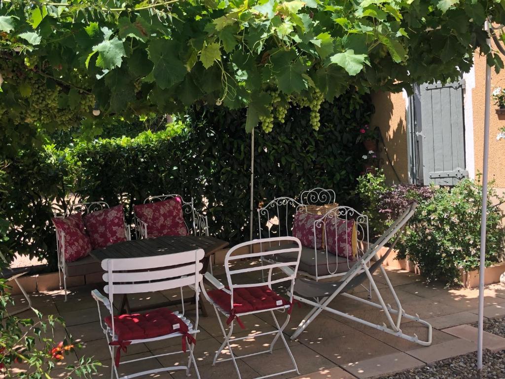 a group of chairs and a table under a tree at La Gatille in Villié-Morgon