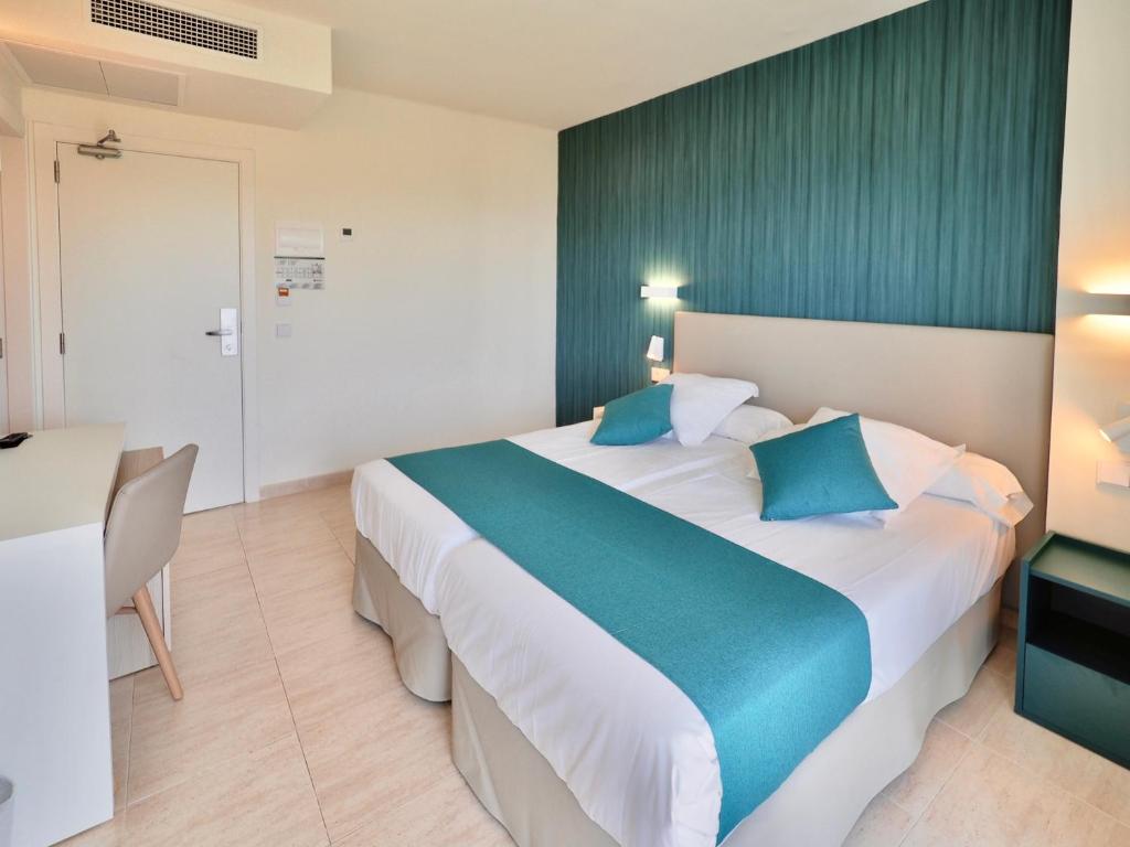a hotel room with a large bed with blue pillows at BQ Belvedere Hotel in Palma de Mallorca