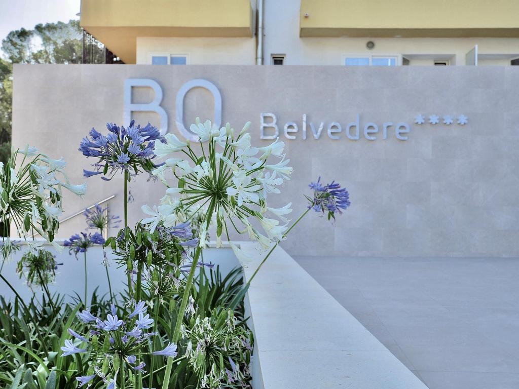 a sign with purple flowers in front of a building at BQ Belvedere Hotel in Palma de Mallorca