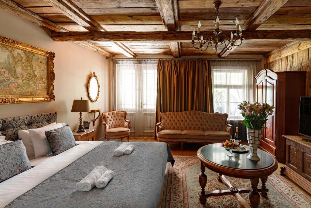 a bedroom with a bed and a living room at Boutique Hotel Virkas muiža in Kuldīga