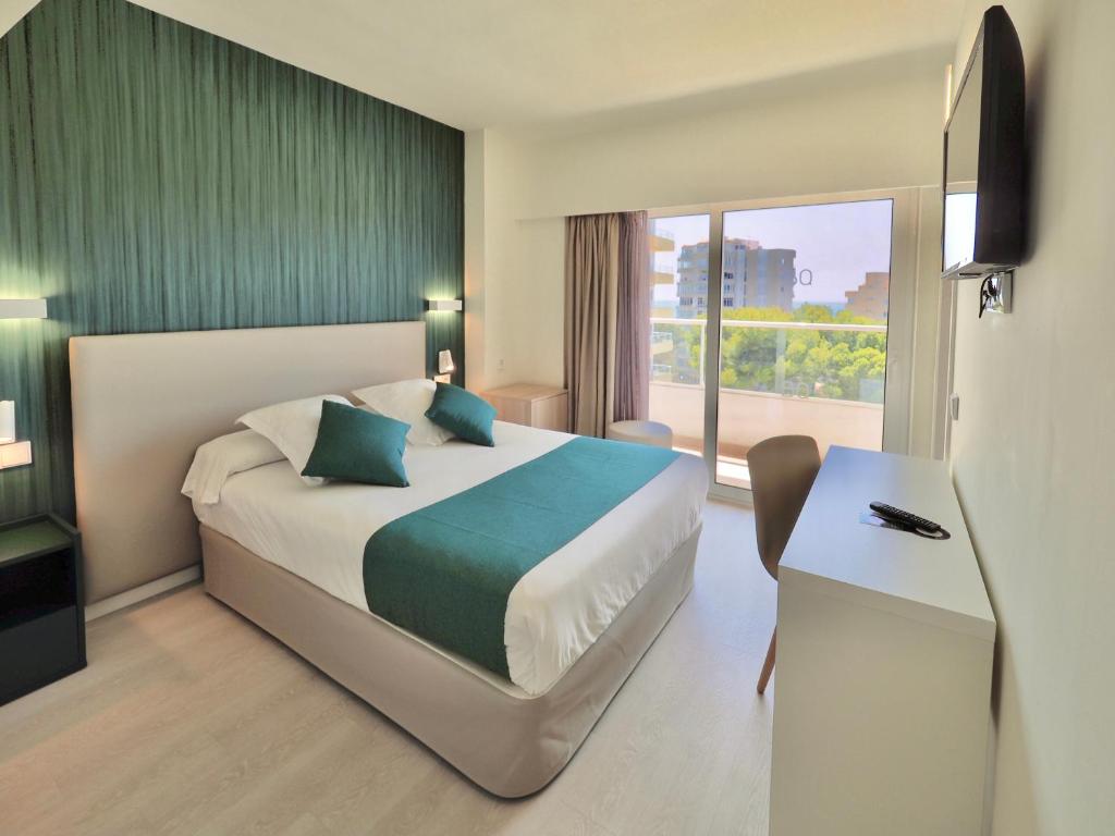 a hotel room with a bed and a desk and a window at BQ Belvedere Hotel in Palma de Mallorca
