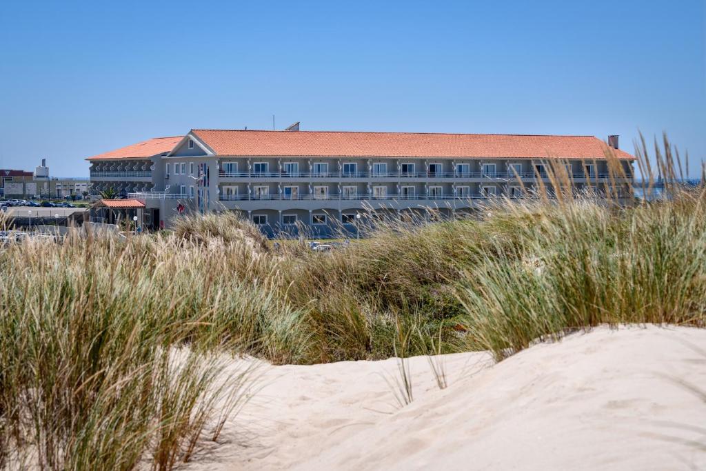 a building on the beach with tall grass at Star inn Peniche in Peniche