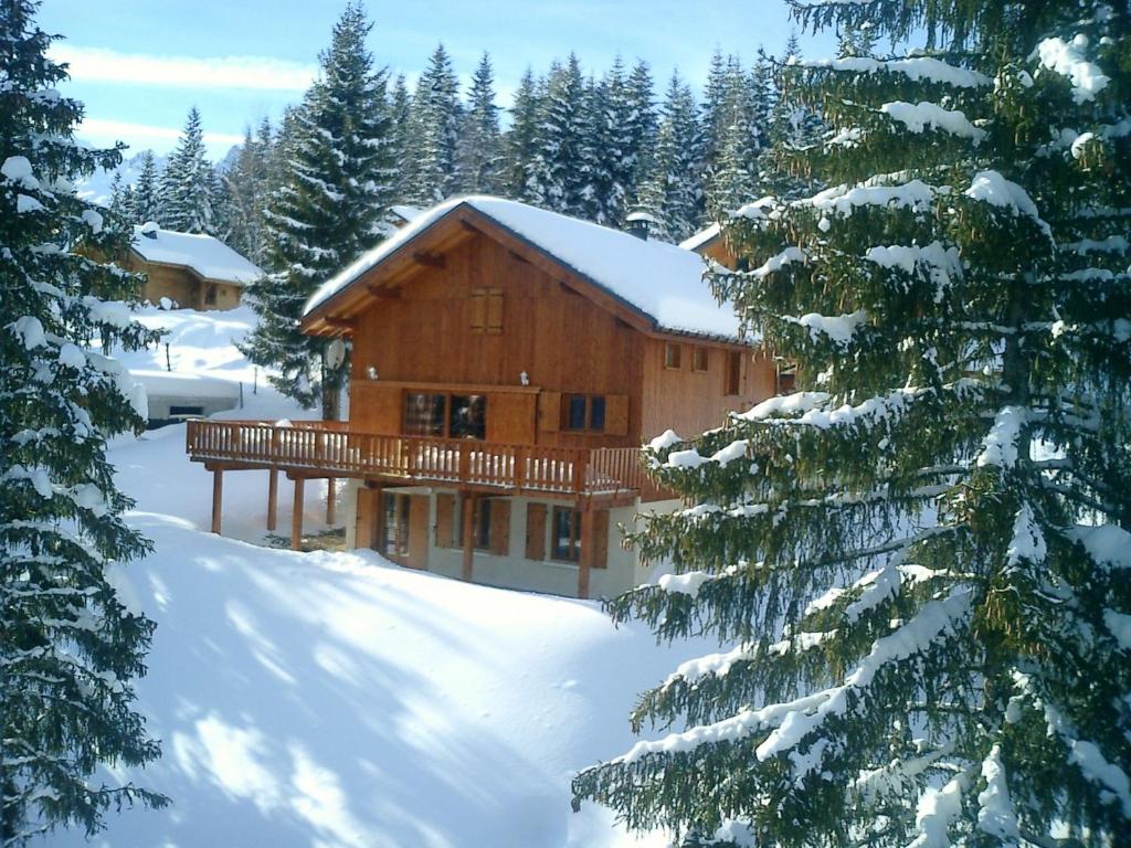 a log cabin in the snow with snow covered trees at CHALET REROLLE in Doucy